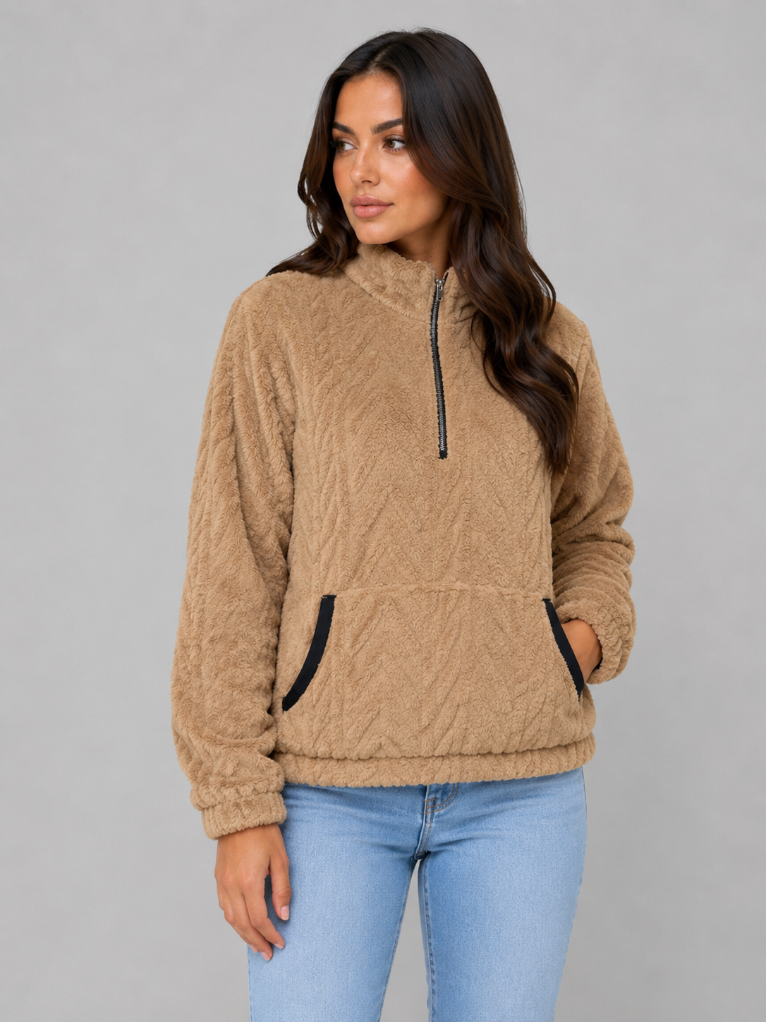 Sudadera de pelo color camel con cuello alto, media cremallera y bolsillo delantero, mostrada en tres cuartos.