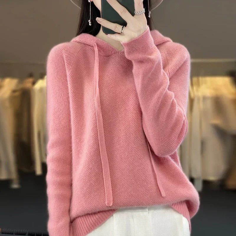 Sudadera de punto oversize rosa claro con capucha, mangas amplias y cordones frontales.