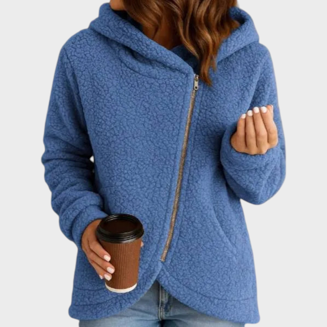 Sudadera azul de corte amplio con capucha y cierre de cremallera diagonal, mostrada con las mangas largas.