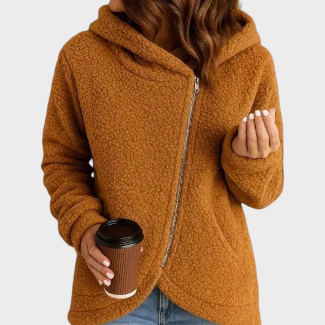 Sudadera color camel con capucha envolvente, mangas largas y cremallera desplazada hacia un lado.
