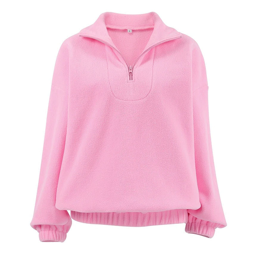Sudadera rosa holgada con cuello alto, media cremallera, mangas largas, puños elásticos y bajo recogido, vista frontal.