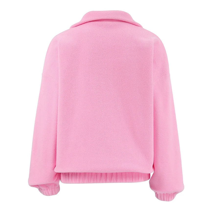Vista posterior de la sudadera rosa holgada, con cuello alto, mangas largas, puños elásticos y bajo recogido.