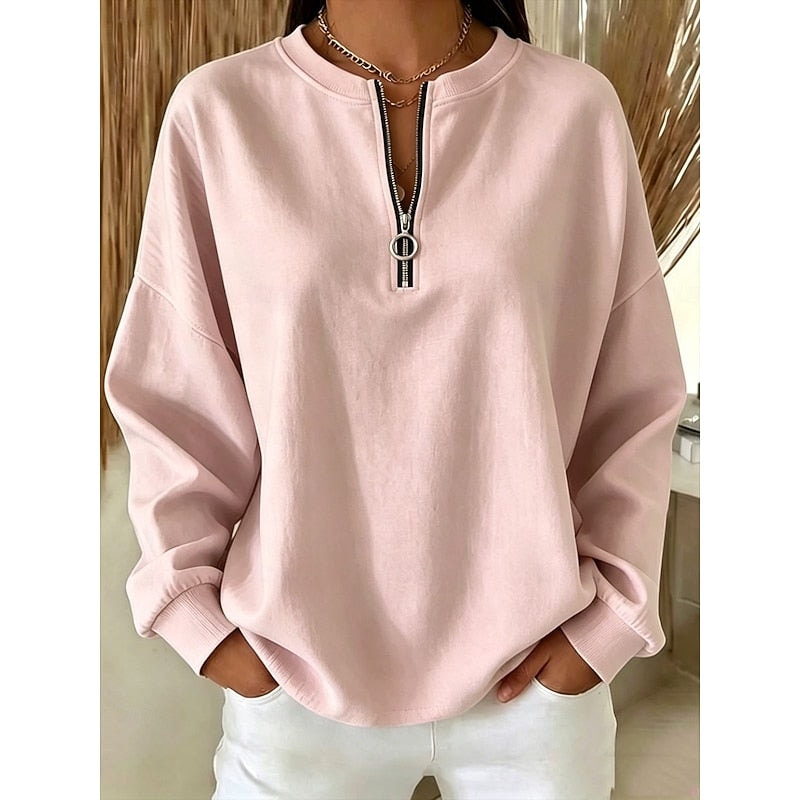 Sudadera holgada rosa claro con bajo redondeado, puños ajustados y media cremallera con tirador de aro.