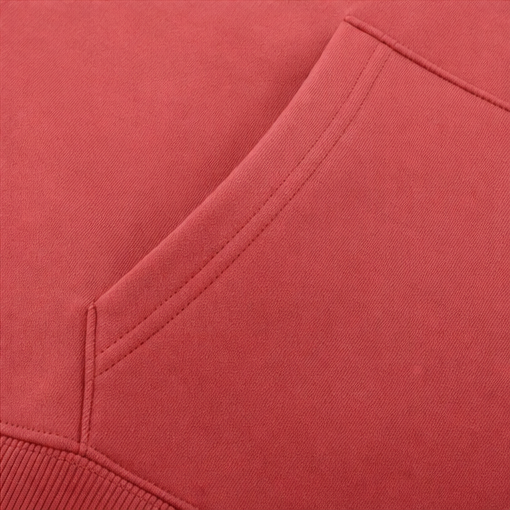 Detalle de las costuras del bolsillo canguro en la sudadera coral.