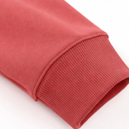 Detalle del puño acanalado de la manga de la sudadera coral.