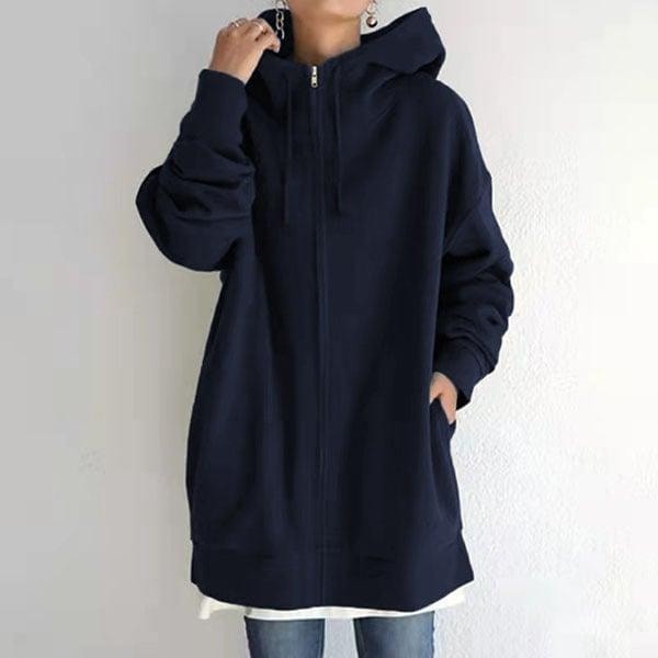 Sudadera oversize azul marino con capucha y cremallera, combinada con una camiseta blanca y vaqueros.