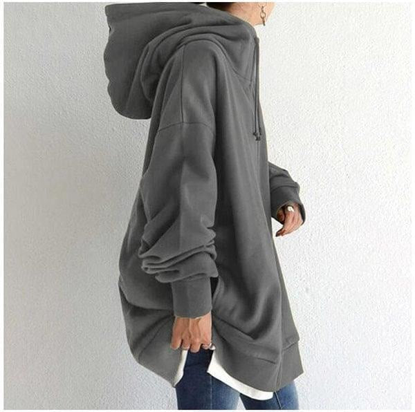 Vista lateral de la sudadera gris oversize que muestra la capucha voluminosa, la manga amplia y el largo holgado.