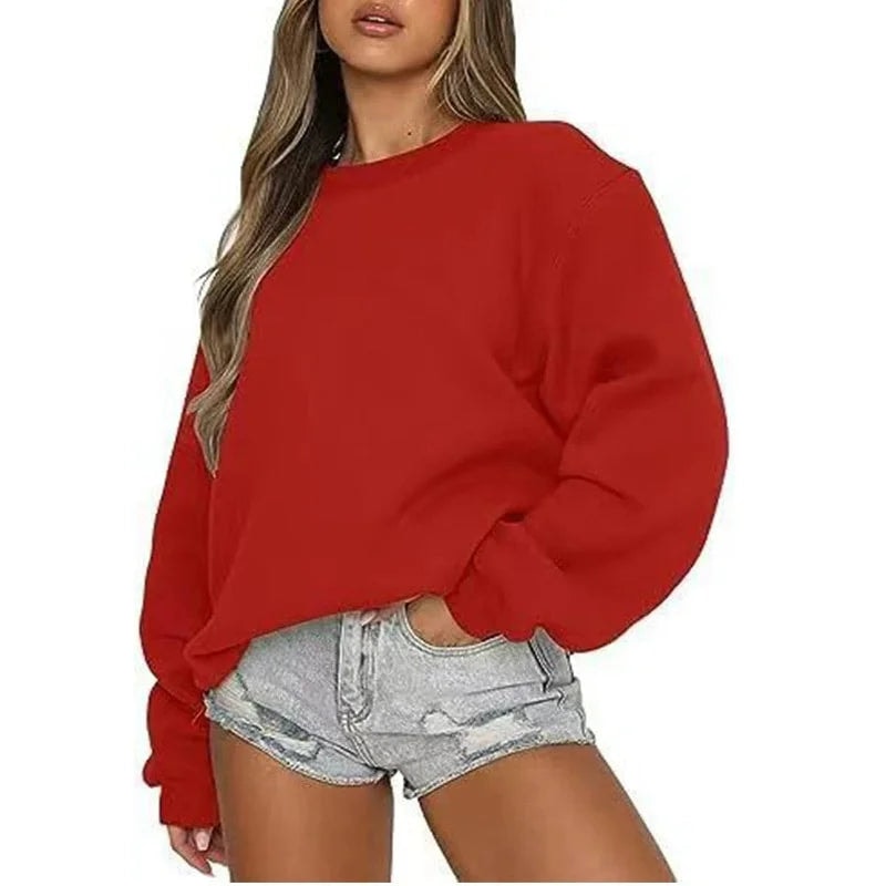 Sudadera oversize roja con mangas amplias y bajo ajustado, llevada con shorts vaqueros.