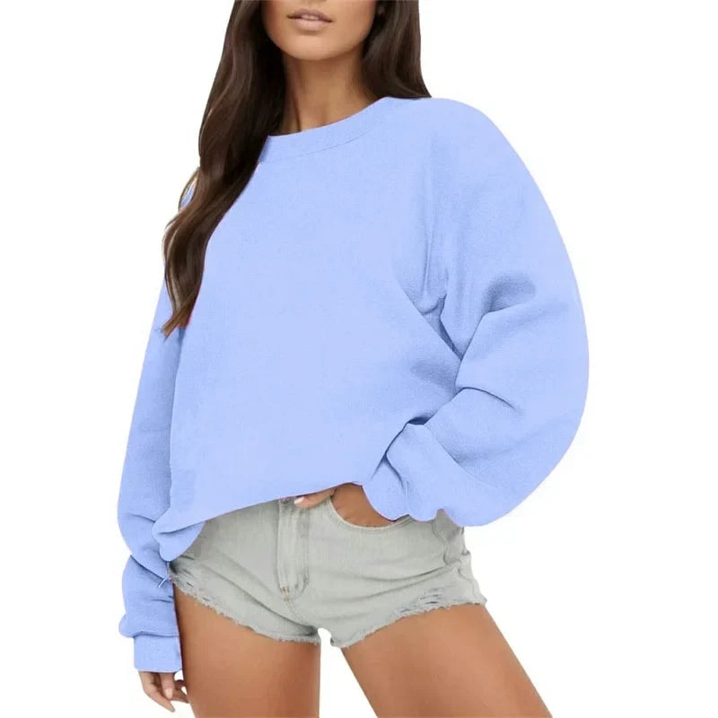 Sudadera oversize azul claro de cuello redondo, con mangas voluminosas y puños ajustados.