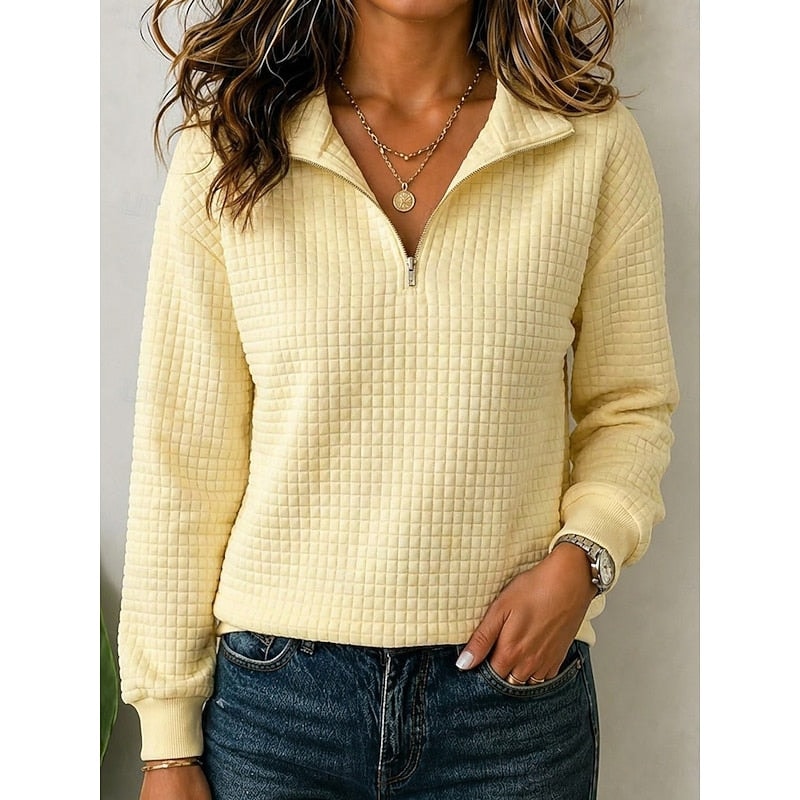 Sudadera texturizada amarilla pálida con cuello de media cremallera, mangas largas y bajo acanalado.