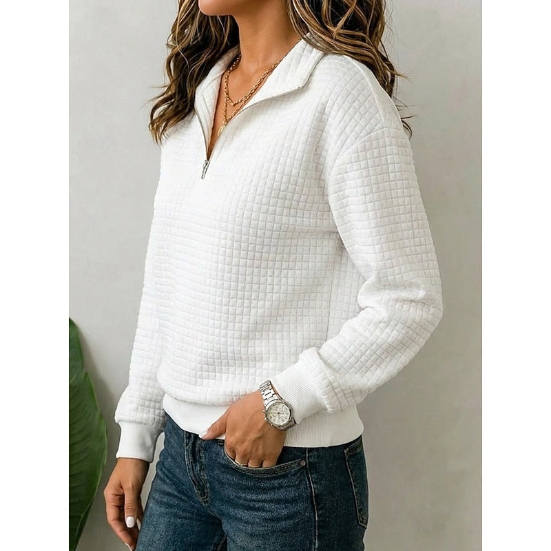 Vista lateral de una sudadera blanca texturizada con cuello de media cremallera, manga larga y bajo acanalado.
