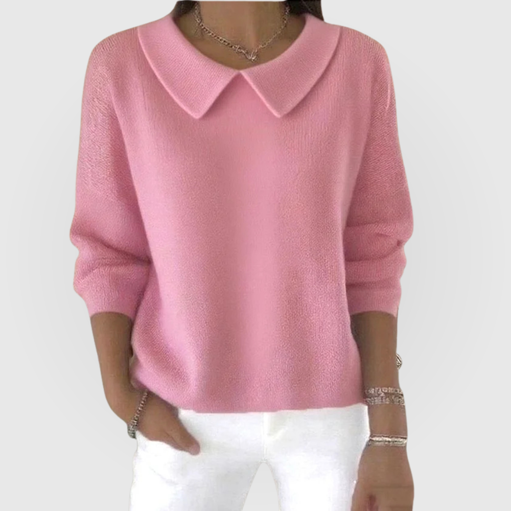 Suéter rosa de manga larga con cuello camisero y puños definidos, mostrado con pantalones blancos.