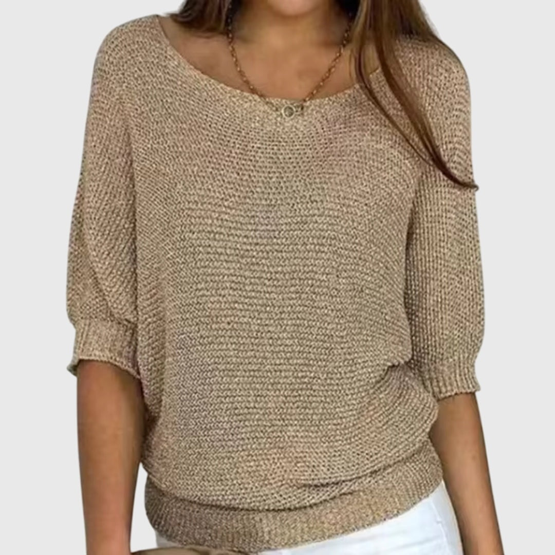 Suéter holgado beige de escote amplio, textura tejida y mangas tres cuartos fruncidas en los puños.