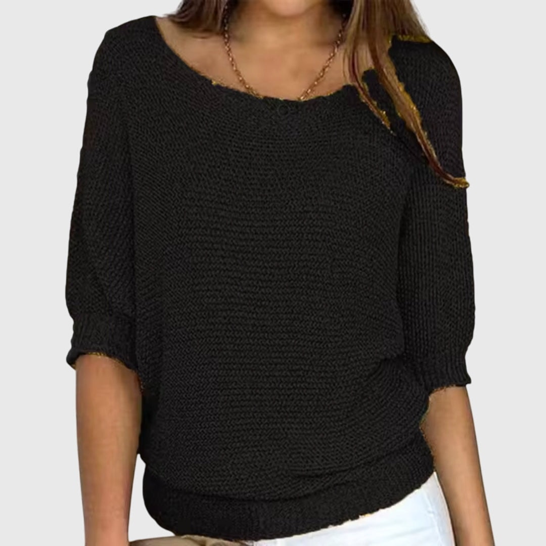Suéter holgado negro de diseño sencillo, escote amplio y mangas tres cuartos con puños ajustados.