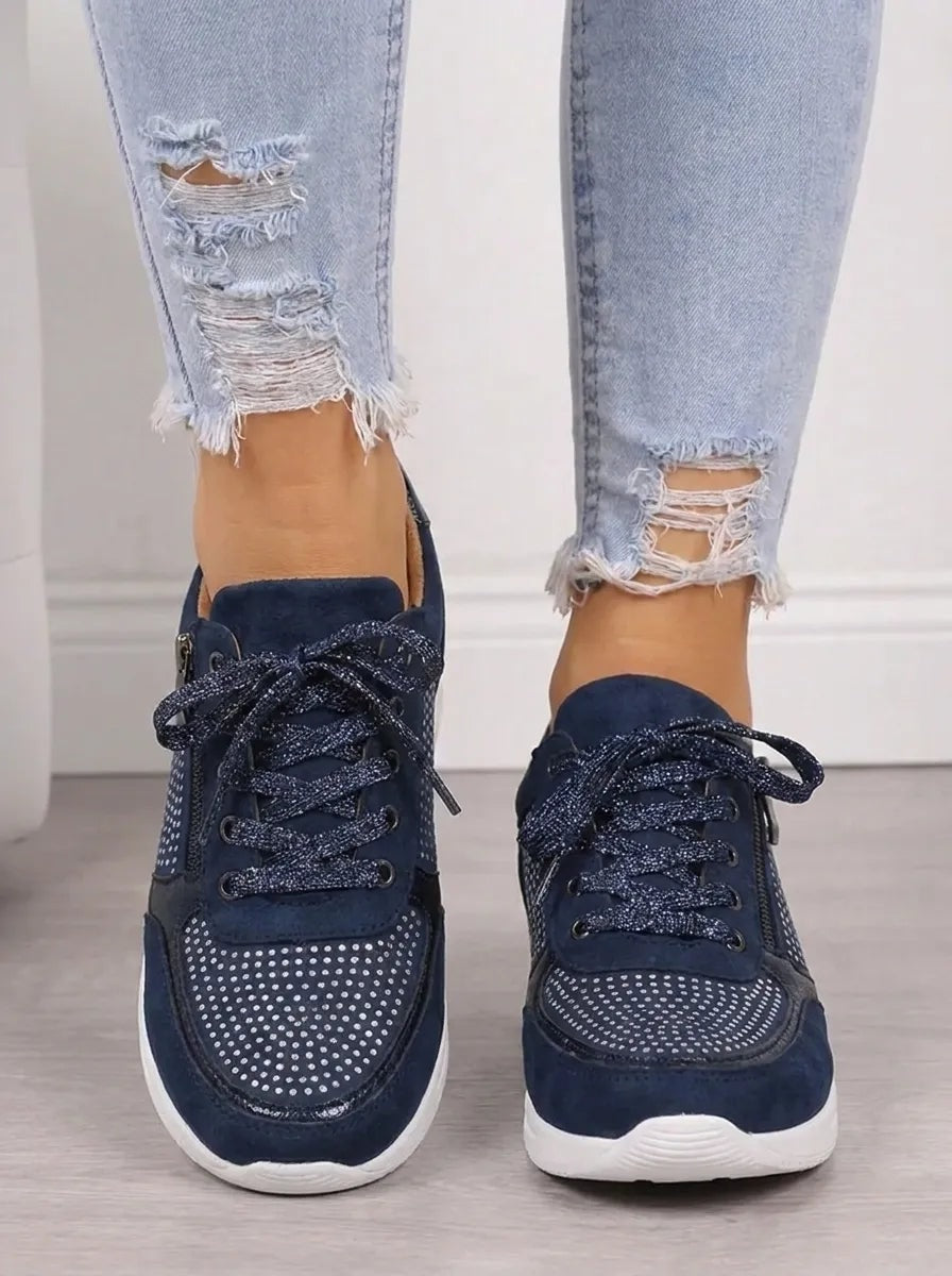 Vista frontal de las zapatillas casual azul marino, con cordones, cremallera lateral y detalles decorativos perforados.