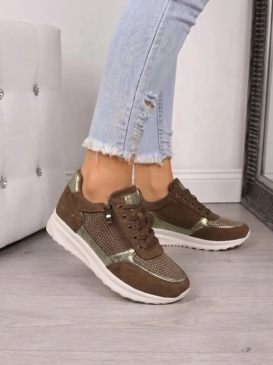 Zapatillas casual en tono marrón, con detalles verde metalizado, cordones, cremallera lateral y suela blanca.