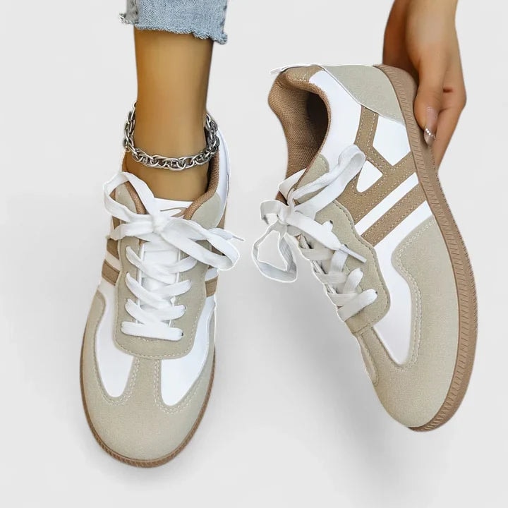 Vista superior de las zapatillas casuales beige y blancas, con cordones blancos destacados y paneles laterales geométricos en contraste.