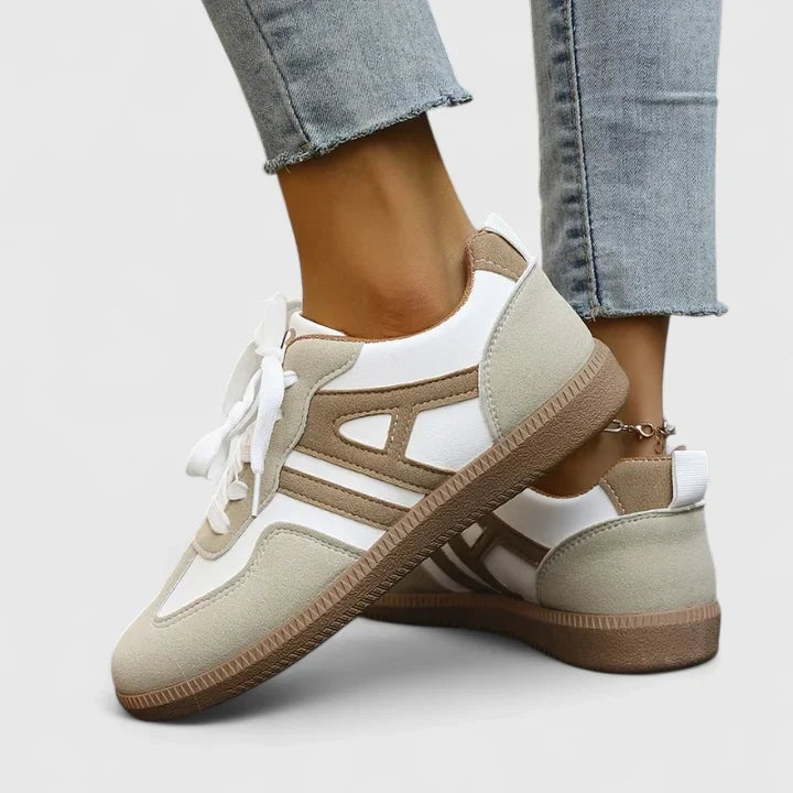 Vista lateral y trasera de las zapatillas casuales con paneles beige y blancos, talón reforzado, tirador posterior y suela plana marrón.