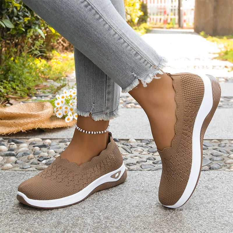 Zapatillas slip-on marrones mostradas de perfil, con una apoyada y la otra elevada.