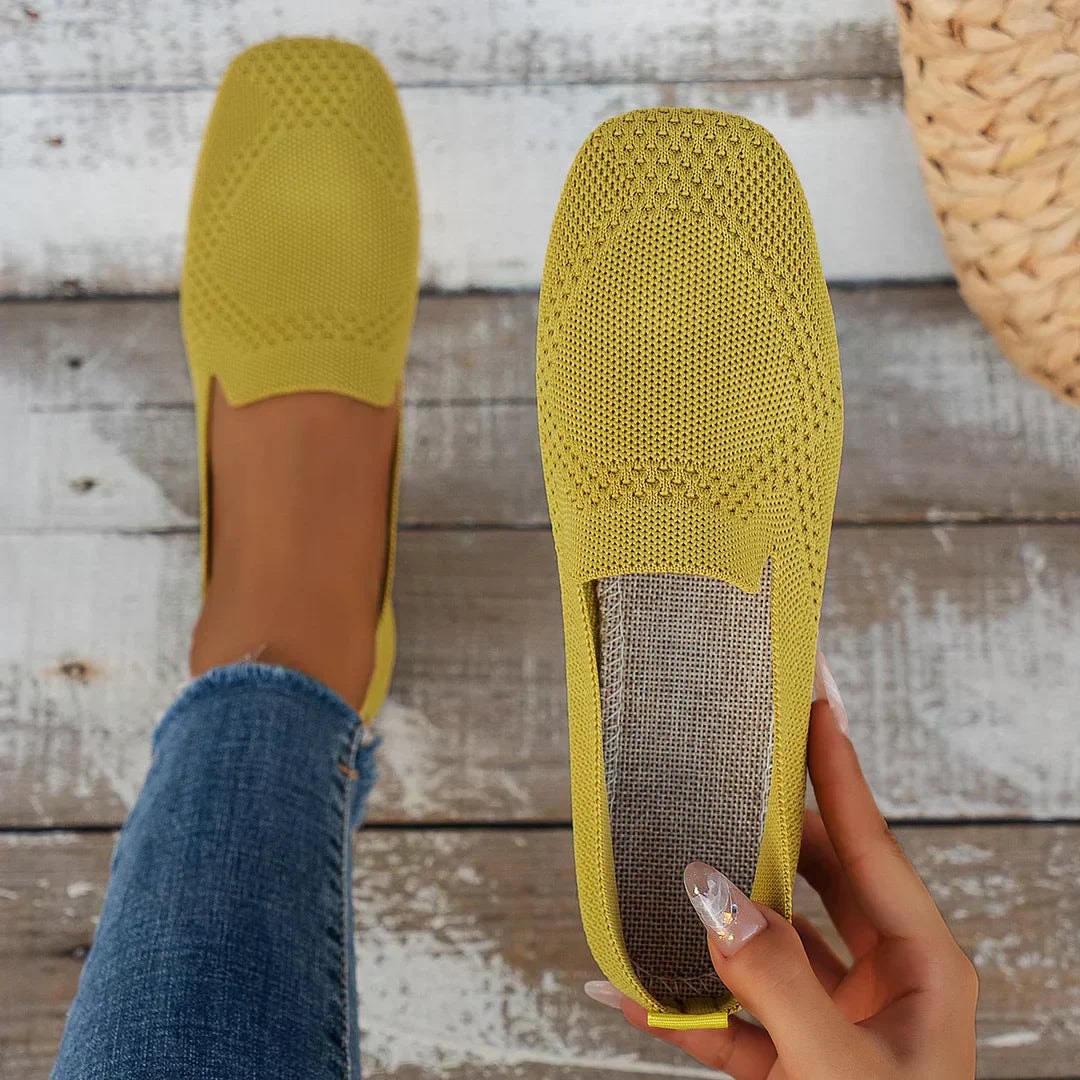 Zapato plano amarillo mostrado por la parte superior, destacando la abertura del empeine y el interior visible.